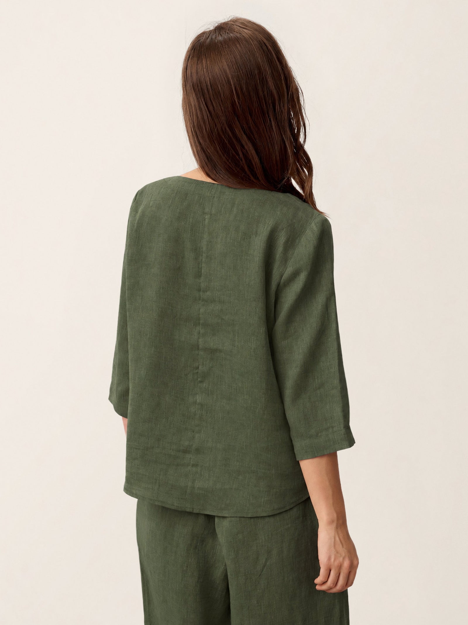 Person wearing a green outfit on a plain background